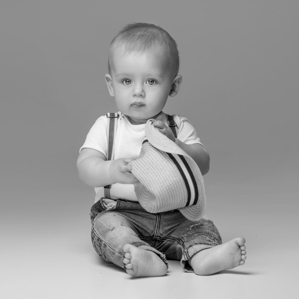 little boy holding a hat
